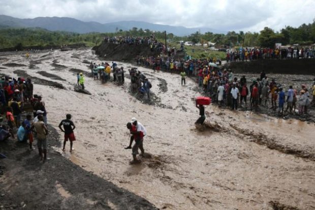 People ty to cross La Digue river due to the collapse of the only bridge that connected the south of the country, after the landfall of hurricane Matthew in Petit Goave, Haiti, 05 October 2016. The southern region of Hiti remains isolated after the reveages of the that hit the country yesterday and caused at least nine dead. EFE/Orlando Barria